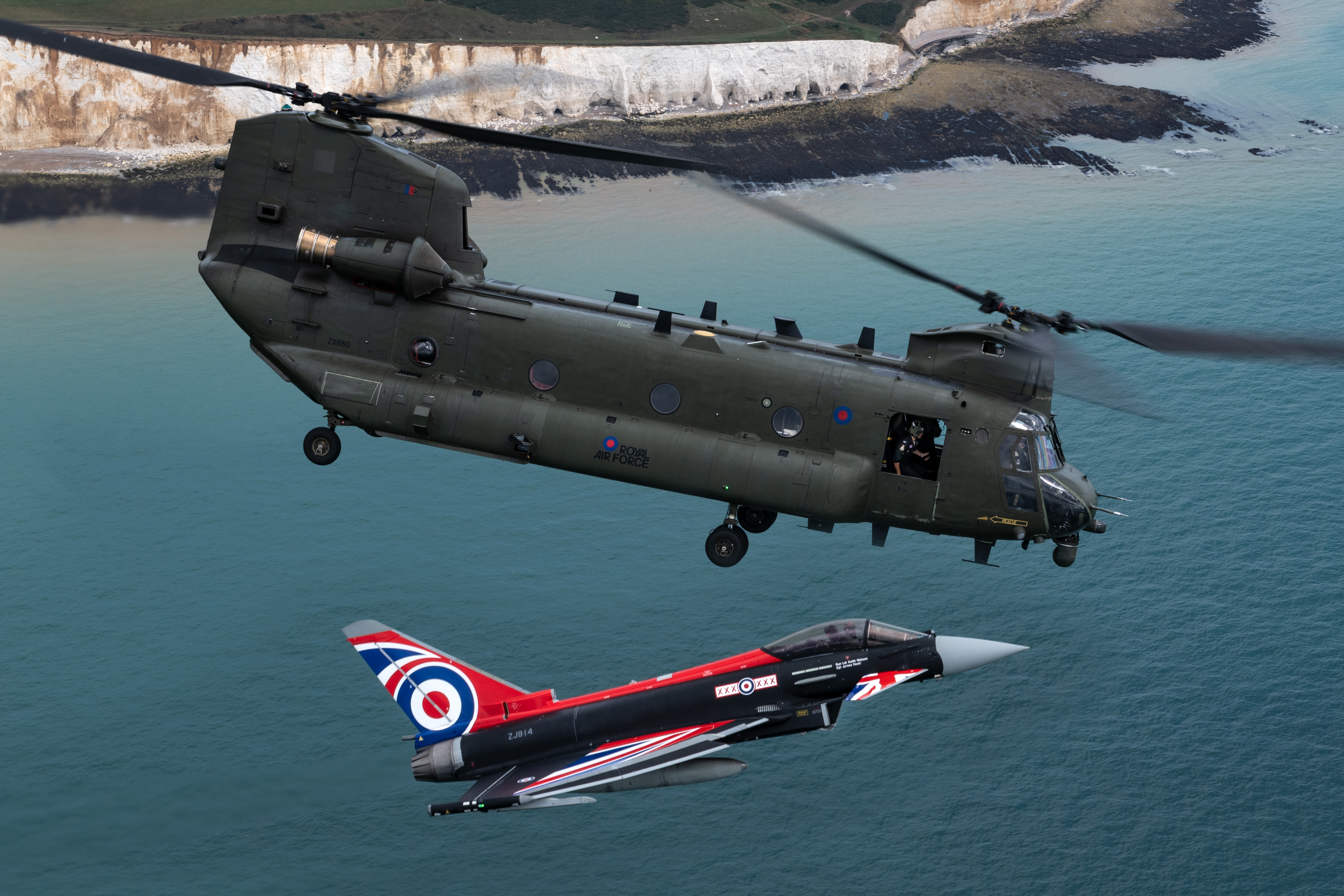Image shows Chinook and Typhoon with Union Jack paint in flight over the white cliffs.